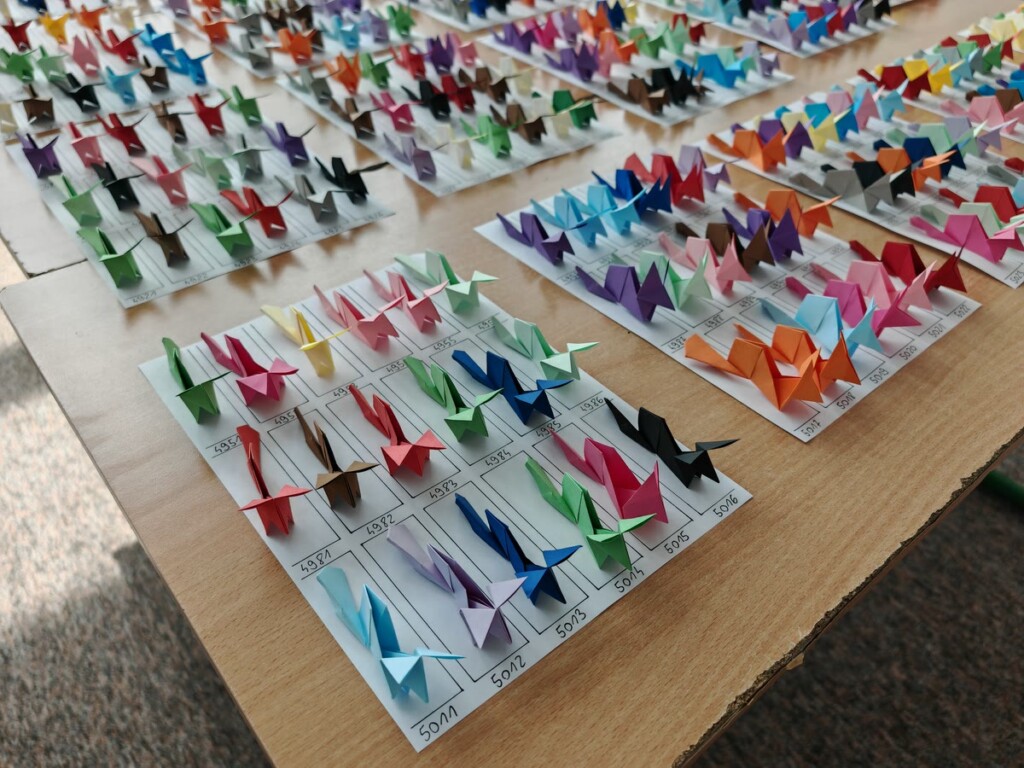 Lisy origami na kartkach z ponumerowanymi polami, każdy lis ma własny numer
